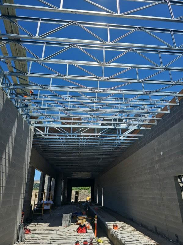Clear span steel roof trusses spanning a commercial shell without interior bearing walls