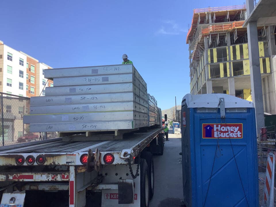 Numbered steel wall panels stacked on a flatbed trailer in erection sequence